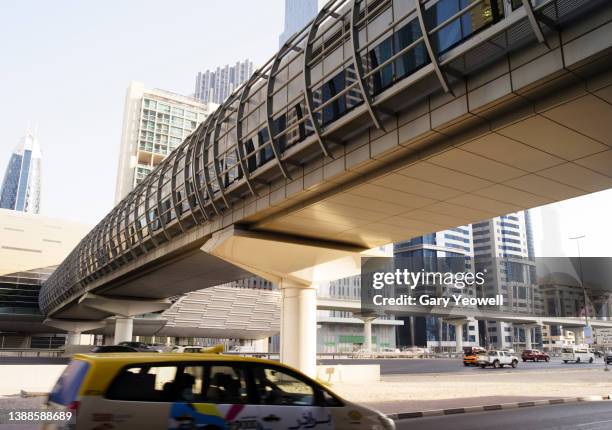 low angle view of sheikh zayed road and skyscrapers and railway overpass in daytime - dubai taxi stock pictures, royalty-free photos & images