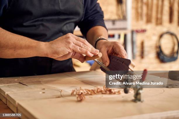 woodworker perforating guitar head in workshop - wood shaving stock pictures, royalty-free photos & images