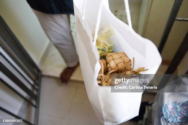 bag of ketupat being delivered for hari raya - raya decoration stock pictures, royalty-free photos & images