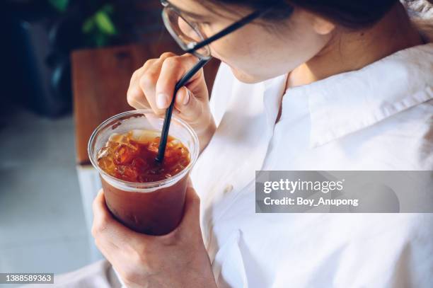 cropped shot of young asian woman while drinking an iced americano coffee. - café preto imagens e fotografias de stock