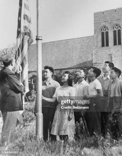 American-born Japanese students watch the raising of the American flag at Park Collect in Parkville, Missouri, 30th August 1942. Despite the protests...