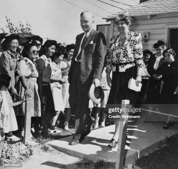 American government official Dillon S Myer , Director of the War Relocation Authority, accompanies First Lady Eleanor Roosevelt , as they are greeted...