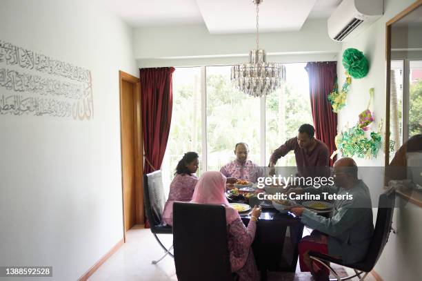 singaporean indian family eating hari raya meal together at home - indian muslims celebrate eid ul fitr stock pictures, royalty-free photos & images