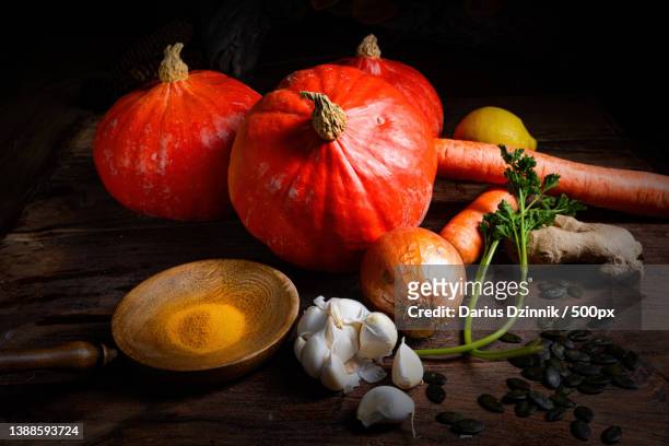 close-up of pumpkin and assorted vegetables on wooden table against black background - gemüse grün ストックフォトと画像