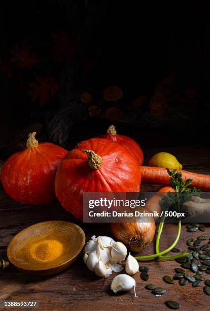 high angle of pumpkin and assorted vegetables on wooden table against black background - gemüse grün stock pictures, royalty-free photos & images