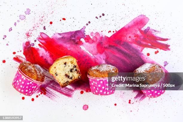 top down view of muffins with pieces of chocolate chips against abstracat spray painted background - muffin top stock-fotos und bilder