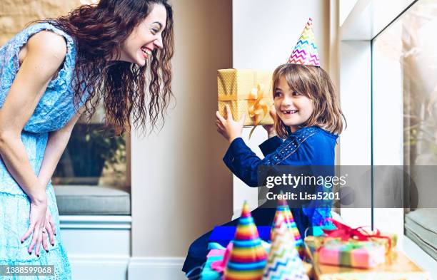 幸せな女性は、彼女の誕生日に女の子にプレゼントを渡す - aunt ストックフォトと画像