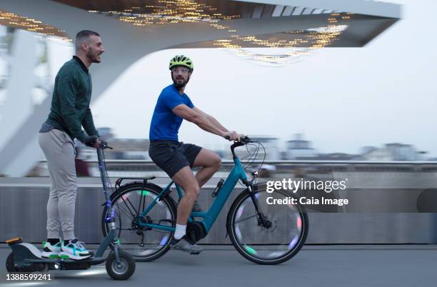 men riding scooter and bicycle along urban waterfront - sparkcykel bildbanksfoton och bilder