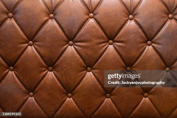 genuine brown leather vintage sofa brown background. - upholstered furniture stock pictures, royalty-free photos & images