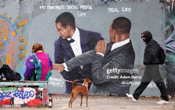 Graffiti depicting a meme showing actor Will Smith slapping comedian Chris Rock, criticizes idealized self-portrayals of social media users' lives,...