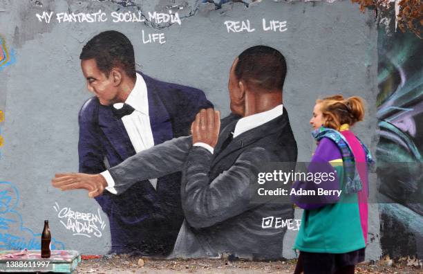 Graffiti depicting a meme showing actor Will Smith slapping comedian Chris Rock, criticizes idealized self-portrayals of social media users' lives,...