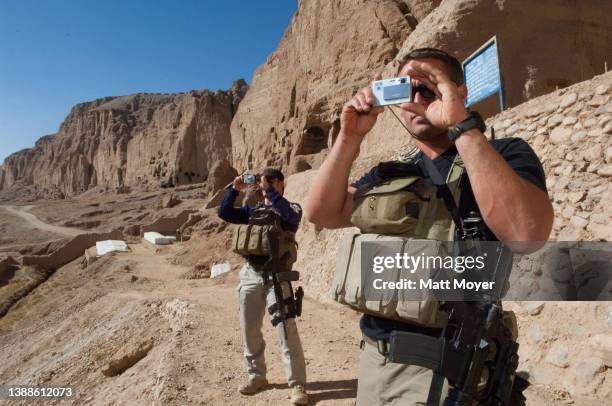 Former US Marines pause to take pictures while sight seeing near where the Taliban destroyed ancient Buddha sculptures in Bamiyan, Afghanistan on...