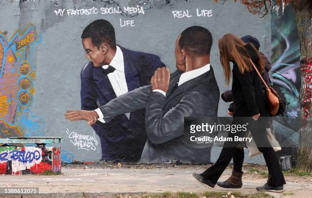 Graffiti depicting a meme showing actor Will Smith slapping comedian Chris Rock, criticizes idealized self-portrayals of social media users' lives,...