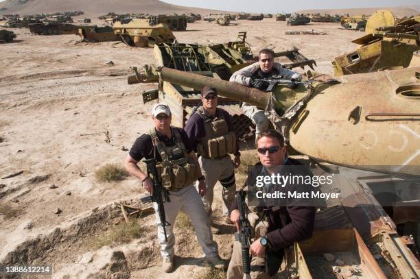 Private security contractors Mike Stocksett Neil Gary Kyle Kaszynski and Pat Scott pose for a photograph in a tank graveyard in Kabul, Afghanistan on...