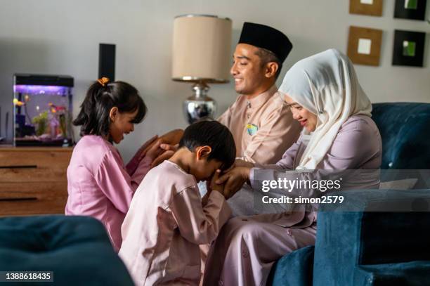 segnungen mit den eltern während des festivals von eid mubarak / hari raya aidilfitri - hari raya celebration stock-fotos und bilder