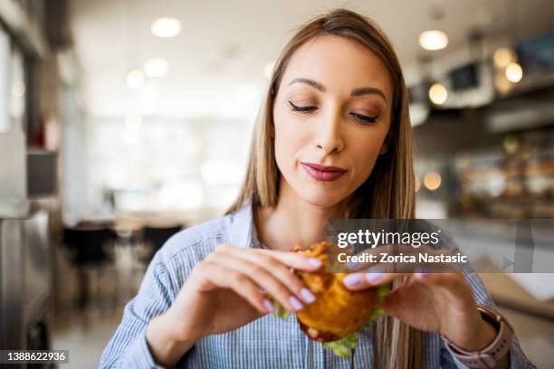 blond woman is about to eat a small sandwich - little burger stock pictures, royalty-free photos & images