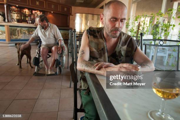 Retired French Foreign Legionnaire stares into his drink at the Legion's retirement home during happy hour in Puyloubier, France on September 14,...