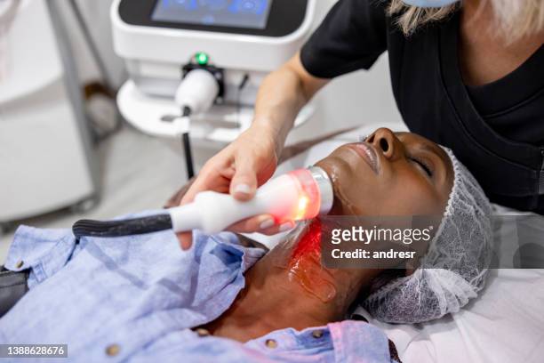 woman at the spa getting a rejuvenation treatment on her neck - electrolysis stock pictures, royalty-free photos & images