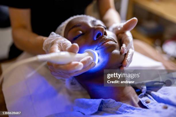 mujer en el spa recibiendo un tratamiento de rejuvenecimiento en su cara - dermatologia fotografías e imágenes de stock