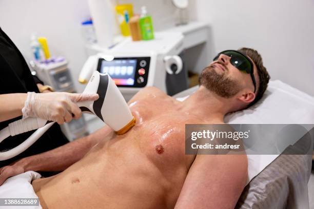 man getting a laser hair removal on his chest - laser stock pictures, royalty-free photos & images