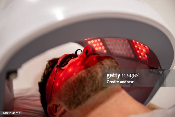 homme dans un spa recevant un traitement de luminothérapie - lampe led photos et images de collection
