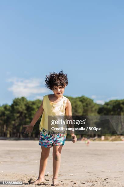 little caucasian girl playing on the beach - brown hair ストックフォトと画像