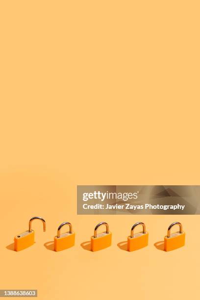 five orange padlocks on orange background - password strength stock pictures, royalty-free photos & images