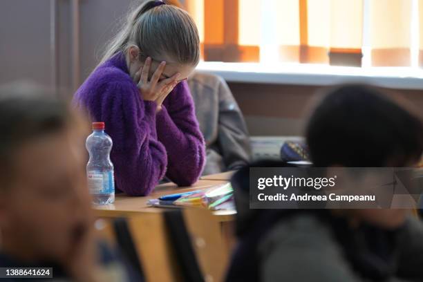 Maria, who is in seventh grade, and has fled the war in Ukraine with her family, reacts as she attends a class at the school in Ruscova, on March 30,...