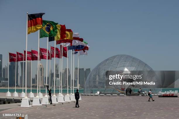 Flags of countries qualified for the FIFA World Cup Qatar 2022 are seen next to 2022 FIFA World Cup countdown clock at Doha's corniche on March 30,...