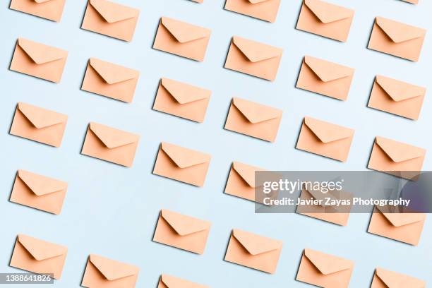 many beige envelopes on blue colored background - letterbox fotografías e imágenes de stock