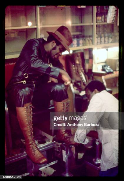 View of an unidentified man as a shoeshiner polishes his boots, Harlem, New York, New York, 1971.