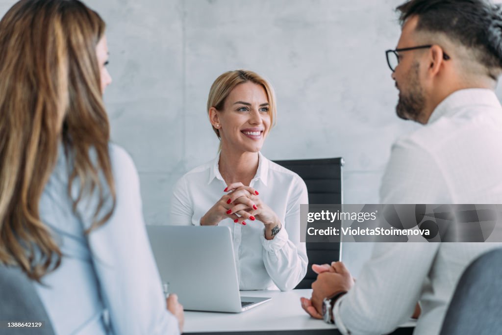 Gruppe von Geschäftsleuten, die im Büro sprechen.