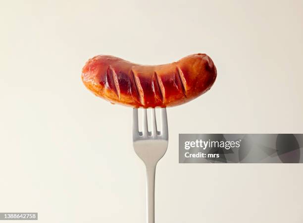 cooked sausage on a fork - salsicha imagens e fotografias de stock