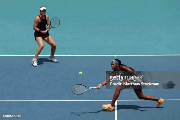 Coco Gauff returns a shot to Alize Cornet of France and Jil Teichmann of Switzerland while playing with Catherine McNally during the Miami Open at...