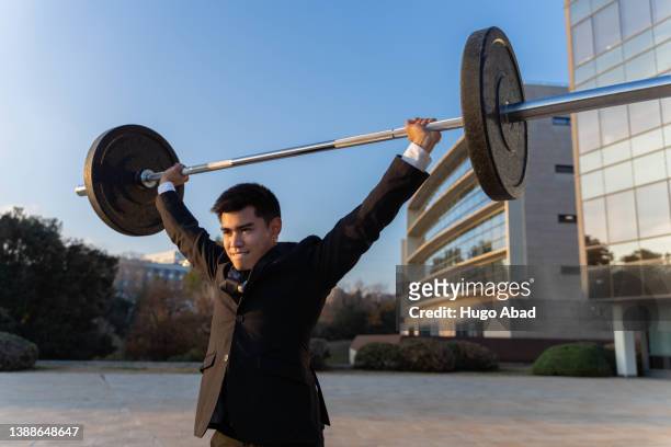 asian businessman doing weightlifting. - turnover sport 個照片及圖片檔
