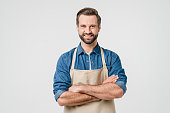 Confident smiling caucasian young man student bartender barista in apron with arms crossed looking at camera isolated in white background. Takeaway food