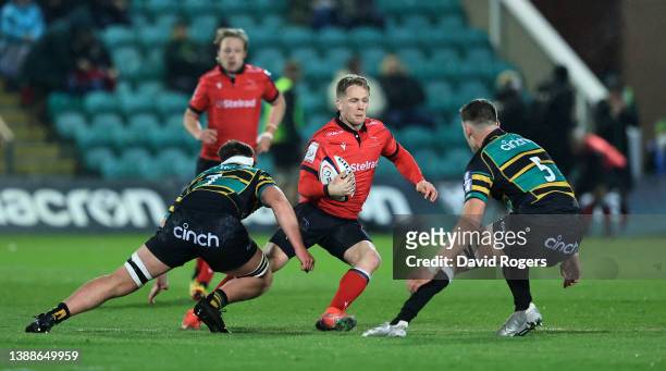 Alex Tait of Newcastle Falcons takes on Tom Litchfield and JJ Tonks during the Premiership Rugby Cup match between Northampton Saints and Newcastle...