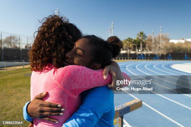 two young women embrace. - showing empathy stock pictures, royalty-free photos & images
