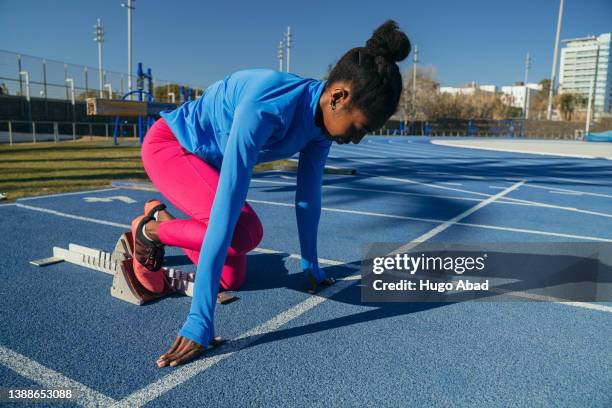 young black woman ready on the starting blocks. - sprinter stock-fotos und bilder