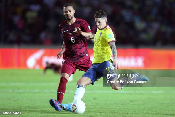 James Rodríguez of Colombia kicks the ball against Yangel Herrera of Venezuela during the FIFA World Cup Qatar 2022 qualification match between...