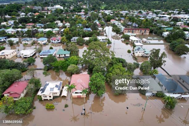 An aerial drone view of houses surrounded by floodwater on March 31, 2022 in Lismore, Australia. Evacuation orders have been issued for towns across...