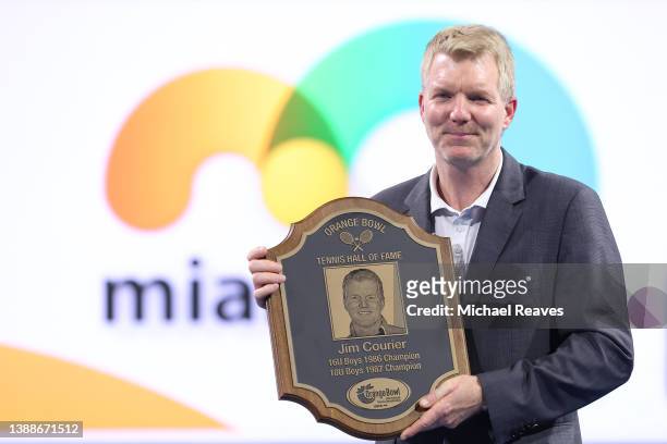 International Tennis Hall of Fame member Jim Courier poses with a plaque as he is inducted into the Orange Bowl Tennis Hall of Fame during the Miami...