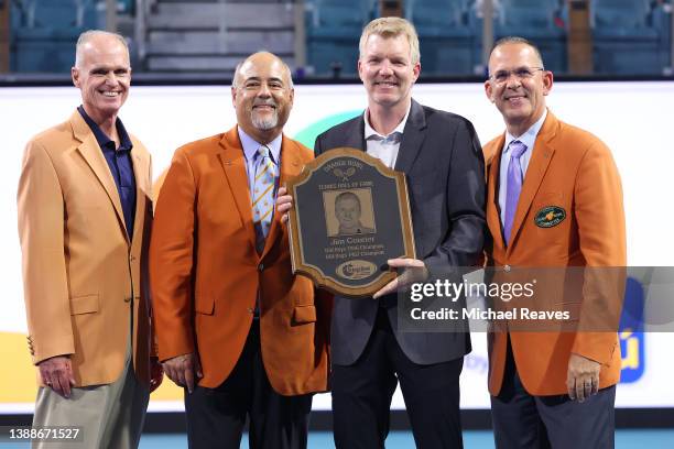 International Tennis Hall of Fame member Jim Courier poses with a plaque and members of the Orange Bowl committee as he is inducted into the Orange...