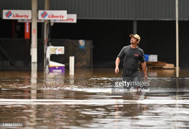 Man walks through floodwater on March 31, 2022 in Lismore, Australia. Evacuation orders have been issued for towns across the NSW Northern Rivers...