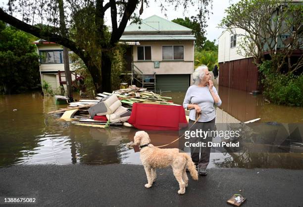 Local resident Cathy Jordan inspects floodwater in her street on March 31, 2022 in Lismore, Australia. Evacuation orders have been issued for towns...