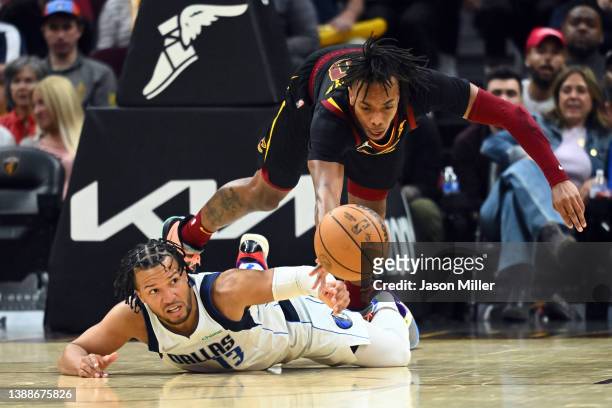 Jalen Brunson of the Dallas Mavericks and Darius Garland of the Cleveland Cavaliers dive for a loose ball during the fourth quarter at Rocket...