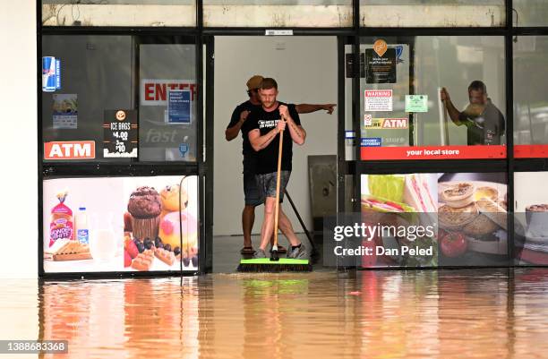 Man pushes water out of a flood-affected business on March 31, 2022 in Lismore, Australia. Evacuation orders have been issued for towns across the...