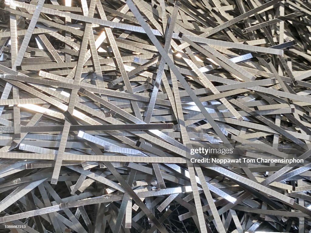 Scrap tinplate sheet laying in piles resulted from food empty can production waiting to be recycled