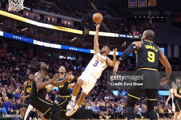 Chris Paul of the Phoenix Suns shoots over Draymond Green of the Golden State Warriors in the final minute of their game at Chase Center on March 30,...