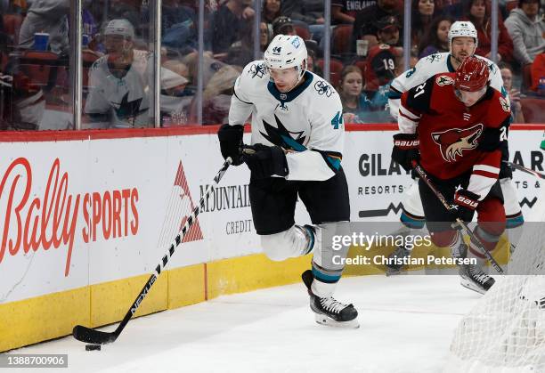 Marc-Edouard Vlasic of the San Jose Sharks skates with the puck ahead of Loui Eriksson of the Arizona Coyotes during the third period of the NHL game...